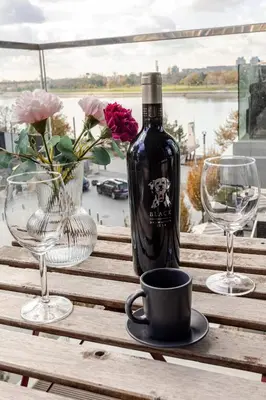 a bottle of wine sitting on a table with two glasses at Belgrade Waterfront Luxury Appartment Pool & Gym in Belgrade