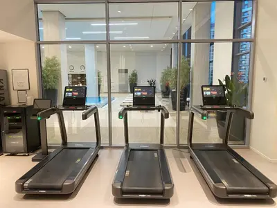 a gym with three treadying machines in a building at Belgrade Waterfront Luxury Appartment Pool & Gym in Belgrade