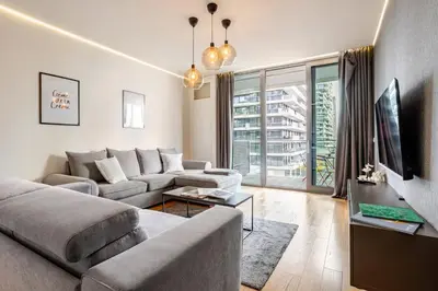 a living room with a couch and a tv at Belgrade Waterfront Luxury Appartment Pool & Gym in Belgrade