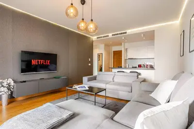 a living room with a couch and a tv at Belgrade Waterfront Luxury Appartment Pool & Gym in Belgrade