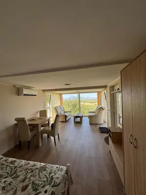 a room with a bed and a table and chairs at Vila POGLED in Arandjelovac