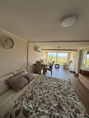 a bedroom with a large bed with a table and chairs at Vila POGLED in Arandjelovac