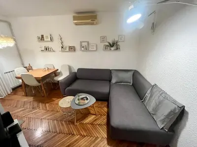 a living room with a couch and a table at Kopernik - parking available in Belgrade