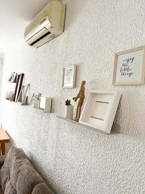 a living room with a white wall with a tv at Kopernik - parking available in Belgrade