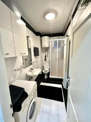 a white bathroom with a sink and a toilet at Kopernik - parking available in Belgrade