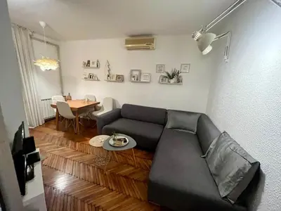 a living room with a couch and a table at Kopernik - parking available in Belgrade
