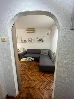 a living room with a couch and a table at Kopernik - parking available in Belgrade