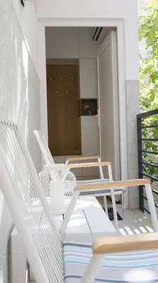 a balcony with white chairs and a table and a refrigerator at Apartment Ana, Vračar, Belgrade in Belgrade