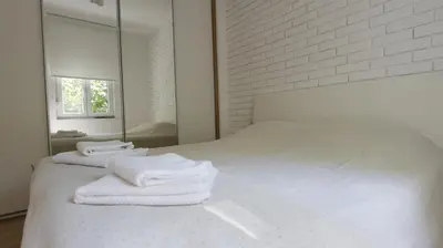 a bedroom with a white bed with towels on it at Apartment Ana, Vračar, Belgrade in Belgrade
