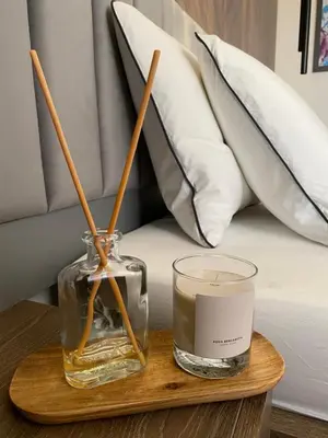 a candle and a glass jar on a table next to a bed at DOM Boutique Apartments PARK VIEW in Belgrade