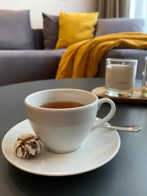a cup of tea and a cookie on a table at DOM Boutique Apartments PARK VIEW in Belgrade
