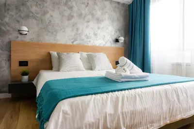 a bedroom with a large bed with a wooden headboard at Akiton Apartment in Belgrade