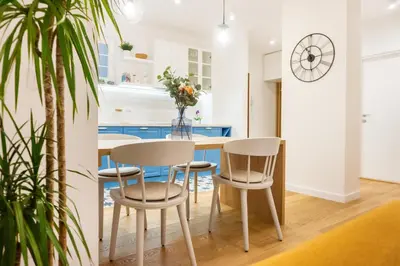 a kitchen with a table and chairs and a clock at Akiton Apartment in Belgrade
