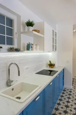 a kitchen with blue cabinets and a sink at Akiton Apartment in Belgrade