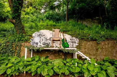 a bench with a guitar sitting on a wall at Wine house apartment in Karaburma