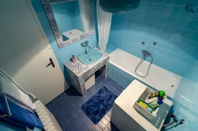 a blue tiled bathroom with a sink and a tub at Wine house apartment in Karaburma