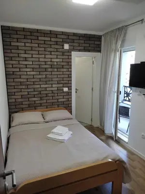 a bed in a room with a brick wall at Apartman 25 in Belgrade