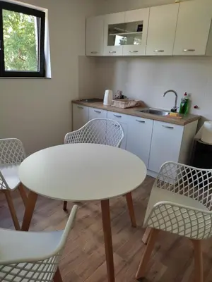 a kitchen with a white table and chairs at Apartman 25 in Belgrade