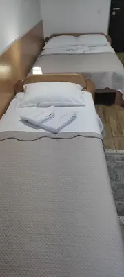 two beds with white sheets and two napkins on them at Apartman 25 in Belgrade