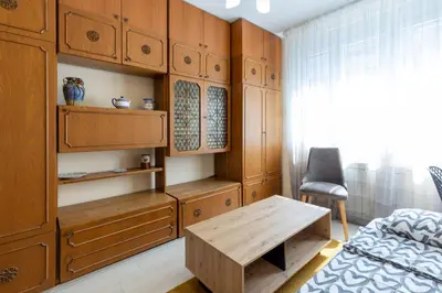 a bedroom with wooden cabinets and a table and a bed at Belgrade Center Apartment Admiral in Belgrade