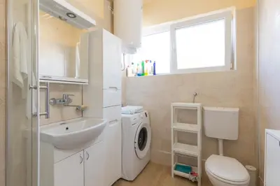 a bathroom with a washing machine and a sink at Belgrade Center Apartment Admiral in Belgrade