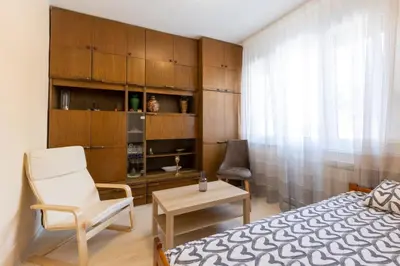 a bedroom with a bed and a chair and a table at Belgrade Center Apartment Admiral in Belgrade