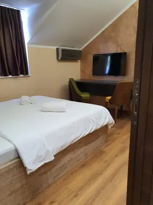 a bedroom with a bed with a desk and a television at Apartmani Mali vikend in Belgrade