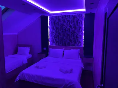 two beds in a room with purple lighting at Apartmani Mali vikend in Belgrade