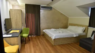 a hotel room with a bed and a desk and chair at Apartmani Mali vikend in Belgrade
