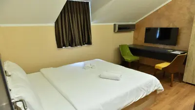 a bedroom with a bed and a desk and a television at Apartmani Mali vikend in Belgrade