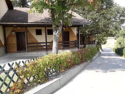 a house with a tree in front of a sidewalk at Hotel Marina Agreena in Grocka