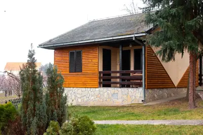 a small wooden house with a stone wall at Hotel Marina Agreena in Grocka
