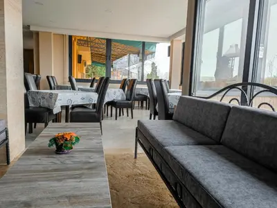 a restaurant with a couch and tables and chairs at Hotel Marina Agreena in Grocka