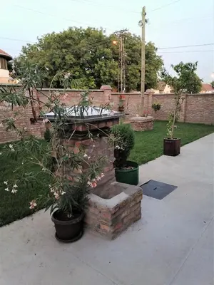 a garden with a stone bench and potted plants at Kućerak X in Ruma