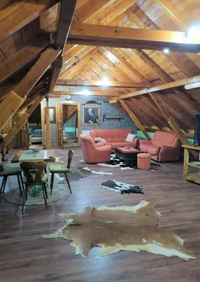a living room with a couch and tables in a attic at Kućerak X in Ruma