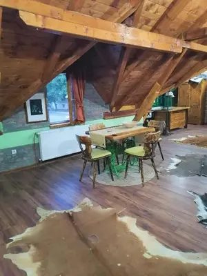 a room with a table and chairs on a wooden floor at Kućerak X in Ruma