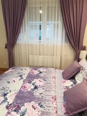 a bedroom with a bed with pink flowers on it at Elena Lux in Belgrade