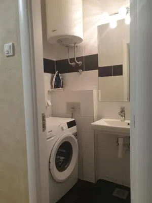 a small bathroom with a washing machine and a sink at Elena Lux in Belgrade