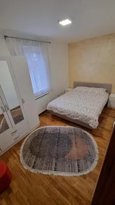 a bedroom with a bed and a rug on a wooden floor at Raven2 in Železnik
