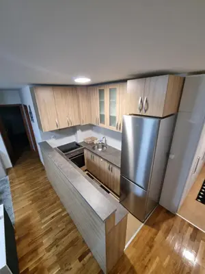a kitchen with a stainless steel refrigerator and wooden cabinets at Raven2 in Železnik