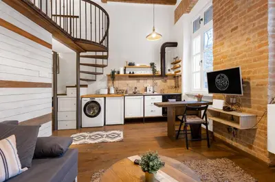 a kitchen and living room with a couch and a table at Old Port Riverside Apartments in City Center in Belgrade