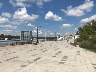 a boardwalk with a bench and a blue sky with clouds at Old Port Riverside Apartments in City Center in Belgrade