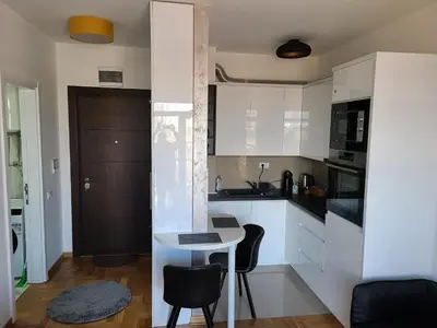 a kitchen with white cabinets and a table and chairs at Bella Vita Dorćol in Belgrade