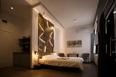 a bedroom with a bed with a large wall at East & West Apartments in Belgrade