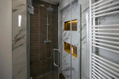 a bathroom with a shower with a glass door at East & West Apartments in Belgrade