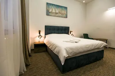 a bedroom with a bed and a desk with a chair at East & West Apartments in Belgrade