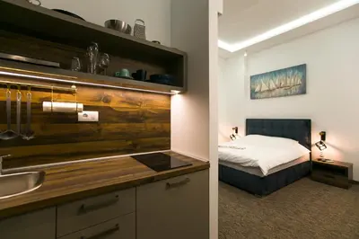 a bathroom with a sink and a bedroom with a bed at East & West Apartments in Belgrade