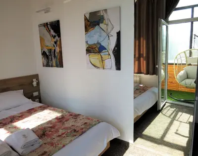 a room with two beds and paintings on the wall at East & West Apartments in Belgrade