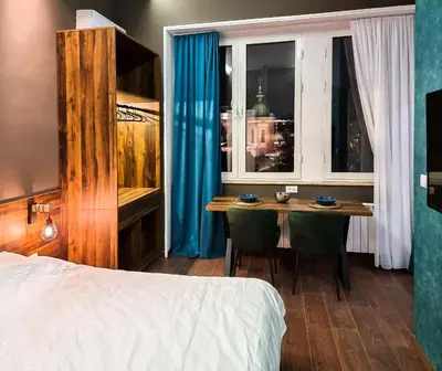 a bedroom with a bed and a table with chairs at East & West Apartments in Belgrade