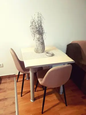 a table with two chairs and a vase on it at Relax, apartman sa garažnim mestom in Obrenovac